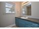 Bathroom with blue vanity, sink, faucet, tile floors, mirror, and a window at 571 Amity Se Ave, Concord, NC 28025