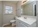 Bathroom featuring a single sink vanity, large mirror, and a window, and tile flooring at 571 Amity Se Ave, Concord, NC 28025