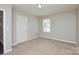 Bedroom showcasing neutral paint, carpet, white door, and window at 571 Amity Se Ave, Concord, NC 28025