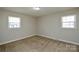 Bedroom with neutral walls and carpet, featuring dual windows for ample natural light at 571 Amity Se Ave, Concord, NC 28025