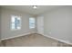 Cozy bedroom with neutral carpet, paint, two windows, and a white door at 571 Amity Se Ave, Concord, NC 28025