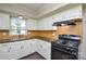 Kitchen featuring white cabinets, dark countertops and appliances, and tile backsplash at 571 Amity Se Ave, Concord, NC 28025