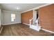 Open-concept living room featuring hardwood flooring and brick accent wall at 571 Amity Se Ave, Concord, NC 28025