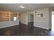 View of an empty living room with open doorways, grey neutral-toned walls, and dark floors at 571 Amity Se Ave, Concord, NC 28025