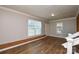 Spacious living room with wood floors, painted walls, a large window, and brick accent at 571 Amity Se Ave, Concord, NC 28025