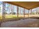 Covered porch looking out to a spacious, tree-lined backyard at 571 Amity Se Ave, Concord, NC 28025