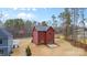 Rear view of red two-story home highlighting the backyard, trees, and construction at 607 W Stanly St, Stanfield, NC 28163