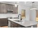 Close-up of a kitchen island with stainless steel sink, gray cabinets, and quartz countertops at 607 W Stanly St, Stanfield, NC 28163