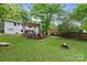 Serene backyard featuring a deck with pergola, a fire pit and a lush lawn at 6126 Netherwood Dr, Charlotte, NC 28210