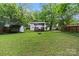 A view of a spacious backyard featuring a deck with a pergola and lush green grass at 6126 Netherwood Dr, Charlotte, NC 28210