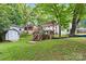 Serene backyard featuring a deck with a pergola, storage shed, and lush green grass at 6126 Netherwood Dr, Charlotte, NC 28210