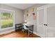 Bedroom featuring hardwood floors and a window view, complemented by a cozy desk area at 6126 Netherwood Dr, Charlotte, NC 28210