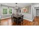 Cozy dining room with modern light fixture and gray decor featuring a dining table with seating and hardwood floors at 6126 Netherwood Dr, Charlotte, NC 28210