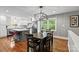 Open-concept dining room with modern light fixture is attached to a kitchen featuring an island and appliances at 6126 Netherwood Dr, Charlotte, NC 28210