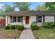 The exterior showcases a well-kept lawn, charming walkway, and meticulously trimmed hedges at 6126 Netherwood Dr, Charlotte, NC 28210