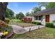 The exterior of this cozy home boasts a paved walkway and lush greenery at 6126 Netherwood Dr, Charlotte, NC 28210