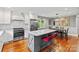 Modern kitchen features an island with seating, white cabinetry, stainless steel appliances, and a nearby dining area at 6126 Netherwood Dr, Charlotte, NC 28210