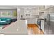 Open layout reveals kitchen featuring stainless appliances, an island with seating, and seamless flow into the living area at 6126 Netherwood Dr, Charlotte, NC 28210