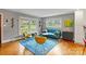 Bright living room showcases a blue couch, vibrant rug, large windows, and trendy furniture at 6126 Netherwood Dr, Charlotte, NC 28210