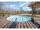 Backyard featuring a refreshing above-ground pool, wooden deck, and tranquil views of the wooded area at 620 Debruhl Rd, Chester, SC 29706