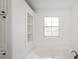 Bright bathroom features a soaking tub, built-in shelving, and a window for natural light at 620 Debruhl Rd, Chester, SC 29706