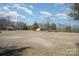 Expansive front lawn showcasing a home nestled among mature trees, under a partly cloudy sky at 620 Debruhl Rd, Chester, SC 29706