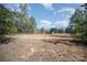 Spacious front lawn leading to a charming home, set against a backdrop of lush trees and a clear blue sky at 620 Debruhl Rd, Chester, SC 29706