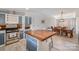 Well-lit kitchen featuring an island with butcher block top, stainless steel appliances, and an open dining area at 620 Debruhl Rd, Chester, SC 29706