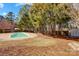 A large backyard featuring a pool, trees and shed; complete with perimeter wood fence at 631 Winding Branch Rd, Rock Hill, SC 29732