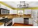 Well-lit kitchen features white cabinets, stainless steel appliances, and decorative backsplash and modern lighting at 631 Winding Branch Rd, Rock Hill, SC 29732