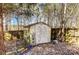 A wooden backyard shed with a ladder sits near the wood fence surrounded by trees and rocks at 631 Winding Branch Rd, Rock Hill, SC 29732