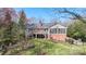 Back exterior of a brick home featuring a deck, screened porch, and a spacious backyard at 710 Peranna Pl, Charlotte, NC 28211