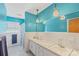 Retro bathroom featuring blue walls, dual sinks, and ample lighting at 710 Peranna Pl, Charlotte, NC 28211