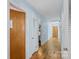 Hallway with wood floors and light blue walls connecting to various rooms at 710 Peranna Pl, Charlotte, NC 28211