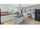 Bright, spacious kitchen with white cabinets, black countertops, tile backsplash, and an island with seating at 710 Peranna Pl, Charlotte, NC 28211