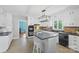 Bright kitchen featuring white cabinets, black appliances, an island with seating, and a tile backsplash at 710 Peranna Pl, Charlotte, NC 28211