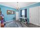 Bright room with blue walls, a modern desk, and a zebra-print rug, offering a unique workspace at 710 Peranna Pl, Charlotte, NC 28211