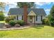 Charming cottage-style home featuring a brick chimney, lush landscaping, and a welcoming front entrance at 7740 Us 52 Hwy, Salisbury, NC 28146