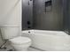 Modern bathroom features a bathtub and shower combo with dark tile and a toilet at 9615 Riviera Dr, Sherrills Ford, NC 28673