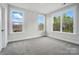 Bright bedroom features three windows that boast outside views and neutral walls with carpet at 9615 Riviera Dr, Sherrills Ford, NC 28673