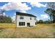 Back of home view with white siding, dark trim, patio seating, and a newly fenced yard at 9615 Riviera Dr, Sherrills Ford, NC 28673