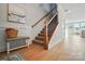 Spacious hallway with hardwood floors, leading to an upper level staircase, a charming bench seat and artwork at 9615 Riviera Dr, Sherrills Ford, NC 28673