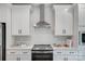 Modern kitchen featuring white shaker cabinets, stainless steel appliances, and a stylish range hood at 9615 Riviera Dr, Sherrills Ford, NC 28673