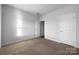 Well-lit bedroom with carpet, two white doors, and a window providing natural light at 9819 Festival Way, Charlotte, NC 28215