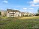 Backyard view of home featuring a well-maintained lawn, wooden fence, and neighboring properties at 9823 Shearwater Nw Ave, Concord, NC 28027