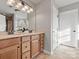 Bathroom with double vanity sinks, light wood cabinets, and warm lighting at 9823 Shearwater Nw Ave, Concord, NC 28027