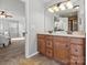 Bathroom with double vanity sinks, light wood cabinets, and tile floors at 9823 Shearwater Nw Ave, Concord, NC 28027