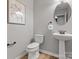 Simple half bathroom with pedestal sink, toilet, and decorative wall art at 9823 Shearwater Nw Ave, Concord, NC 28027