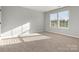 Bright bedroom featuring neutral walls and carpeting, and a large window for natural light at 9823 Shearwater Nw Ave, Concord, NC 28027