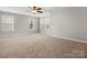 Spacious bedroom with three large windows providing ample natural light and neutral carpeting at 9823 Shearwater Nw Ave, Concord, NC 28027